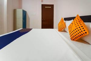 瓜廖尔SPOT ON 66974 Hotel shri gurukripa的一间卧室配有带两个橙色枕头的床