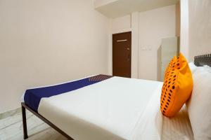 瓜廖尔SPOT ON 66974 Hotel shri gurukripa的一间卧室配有一张带橙色枕头的床