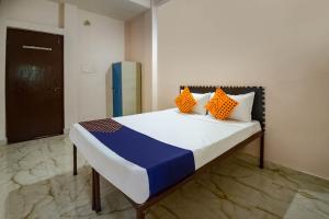 瓜廖尔SPOT ON 66974 Hotel shri gurukripa的橙色和蓝色枕头的宿舍间内的一张床位