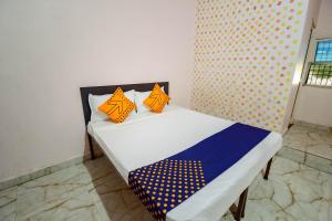 瓜廖尔SPOT ON 66974 Hotel shri gurukripa的一张带橙色和蓝色枕头的床