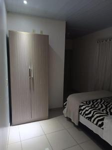 拉热斯Pousada Tertulia Apartamento completo em Lages!的一间卧室配有一张床和一个大衣柜