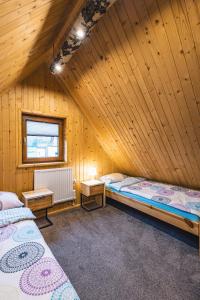 拉普斯尼恩Domek na Leśnej的木屋内带两张床的房间