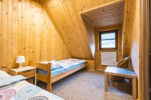 拉普斯尼恩Domek na Leśnej的小木屋内的小房间,配有一张床