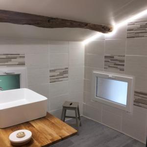 圣瑞尼安安塔迪奥旅馆的带浴缸的浴室和墙上的电视