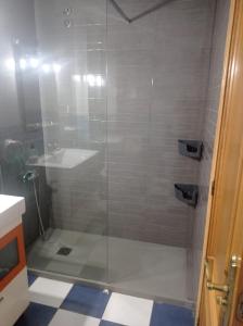 莱斯卡瑟斯-达尔卡纳Apartamento con piscina的玻璃门淋浴和水槽