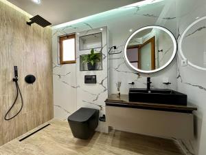 卡萨米尔Vila Laura的浴室设有黑色水槽和镜子