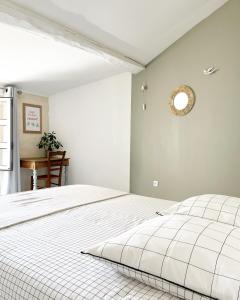 MouchampsLe 19 Rue **,Maison de charme proche du Puy du Fou的卧室配有白色床,墙上挂着时钟