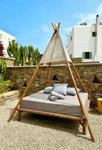 米克诺斯城Sofos Suites Mykonos的庭院内的一张带木架的吊床