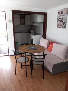 代尔尼采Apartman Ris Gorski Kotar Crni Lug的客厅配有桌子和沙发