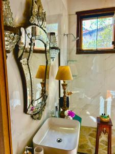 蒂拉登特斯Segredo da Serra Guest House的浴室设有水槽和墙上的镜子