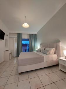 帕莱欧卡斯提撒Maria Studios的卧室配有一张白色大床和电视。