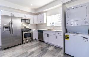 洛杉矶Ktown Homestay的厨房配有白色橱柜和不锈钢用具