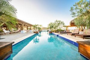 普拉纳维瑙Villa #13 - Blue Venao, Playa Venao的一个带椅子和树木的度假村游泳池