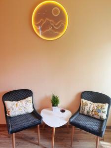 布达佩斯Garden villa的两把椅子和一张桌子,墙上有盘子