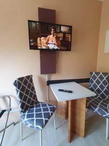 科隆CityPark Aparthotel的配有桌子和两把椅子以及电视的房间