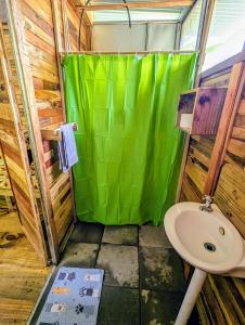 乌维塔Arboura Eco Cabins的浴室设有绿色的淋浴帘和水槽