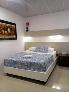 巴克里索莫雷诺港洛斯阿尔加鲁博斯旅舍的一间卧室配有一张带蓝色棉被的床