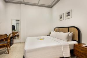 日惹CERIA HOTEL at Alun Alun Yogyakarta的卧室配有一张白色大床和一张书桌