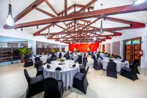 阿皮亚塔诺阿图斯塔拉酒店的宴会厅配有白色桌子和黑色椅子