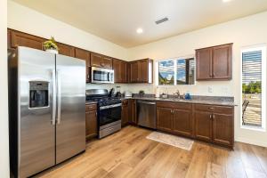 弗拉格斯塔夫New Flagstaff Adventure Getaway的厨房配有木制橱柜和不锈钢冰箱。