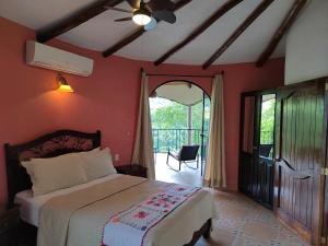 希利特拉Hotel Paraíso Encantado的一间卧室设有一张床,并有通往阳台的门