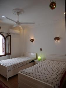 卢克索Villa Quiet Place的一间卧室配有两张床和吊扇