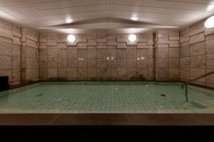 千叶Vessel Inn Chiba Ekimae的一个带两个灯的游泳池的房间