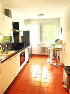 格拉茨University Messe Apartment的厨房铺有橙色瓷砖地板,配有桌子。