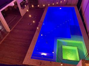 El Paredón Buena VistaMAYAN SURF HOTEL的蓝色的游泳池设有楼梯和灯光