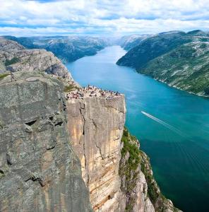 索拉Enjoy Entire Condo near Stavanger airport的一群人,在悬崖边,俯瞰湖泊