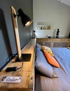 Puimoisson匹吉奥尼尔班农斯住宿加早餐旅馆的一间卧室配有一张带台灯的桌子的床