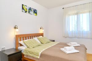 木洛希尼Argo Apartmani的一间卧室配有一张大床和两条毛巾