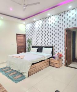 PrayagrajMauji's Villa Hotel & Guest House的一间卧室配有一张床,墙上配有波卡点