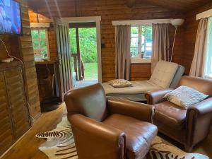 Crich3bears Log Cabin Whatstandwell Matlock Derbyshire的客厅配有真皮沙发和电视