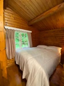 Crich3bears Log Cabin Whatstandwell Matlock Derbyshire的小木屋内一间卧室配有一张白色的床