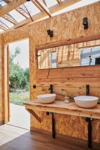 HozanejosTranquilo Glamping的木墙上带两个水槽的浴室