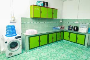巴西富地D'BALI HOMESTAY - Unifi TV, NETFLIX, Cuckoo, Internet Wifi , Dryer, Washing Machine, Aircond Setiap Bilik & Ruang Tamu的厨房配有绿色橱柜和洗衣机。