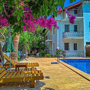 达利安Işıl Suit Apart Otel的一座带游泳池和大楼的度假村