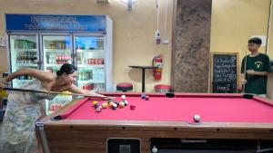芭东海滩Lucky Buako Hotel Patong的一名妇女在台球桌旁打台球