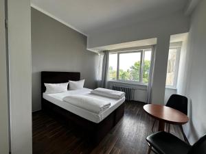 柏林Ootel.com的一间卧室配有一张床、一张桌子和一个窗户。