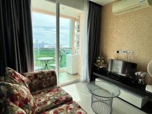 南芭堤雅Grande Cariibbean Pattaya by Thita的带沙发和电视的客厅以及阳台。