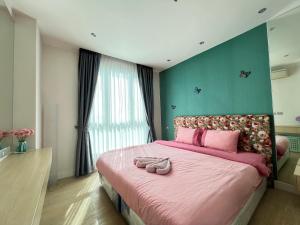 南芭堤雅Grande Cariibbean Pattaya by Thita的一间卧室配有粉红色的床,上面有两双鞋