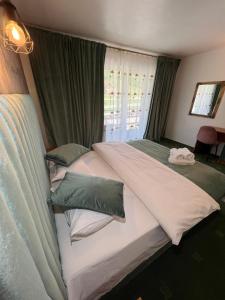 波亚纳布拉索夫Top Mountain的一间卧室配有两张带绿色和白色枕头的床