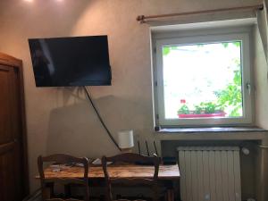 RémalardDomaine Moulin de Boiscorde的靠桌子边的墙上的电视机,有窗