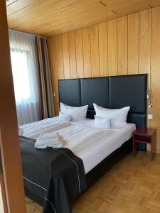 锡根舍费尔酒店的一张大床,在房间里设有黑色床头板