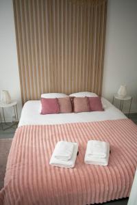 博韦Le Cosy - Centre Ville - 2 pièces的一间卧室配有一张大床和毛巾