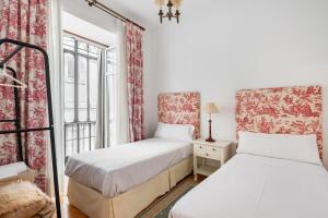 塞维利亚Komodo Sierpes: Bright & Classy Central Apartment的带窗户的客房内的两张床