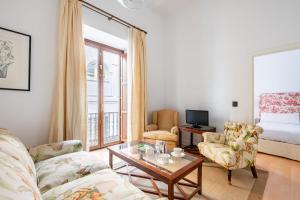 塞维利亚Komodo Sierpes: Bright & Classy Central Apartment的客厅配有沙发和桌子