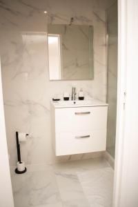博韦Le Cosy - Centre Ville - 2 pièces的白色的浴室设有水槽和镜子