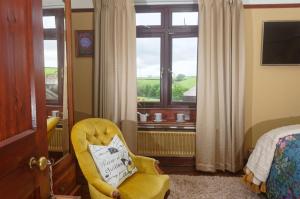 利斯卡德特格达尔住宿加早餐旅馆的一间卧室配有黄色椅子和窗户